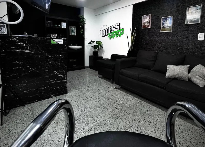 Recepción de Bless Faded con mostrador de mármol negro, sofá y el logo en la pared