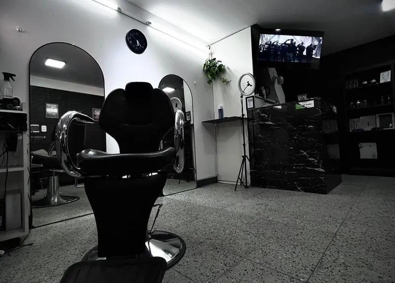 Sillón de barbero con detalles cromados frente a los espejos de arco de Bless Faded